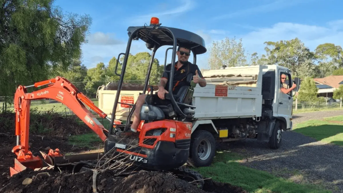 The Kubota excavator digging a trench on a tight-access Toowoomba block