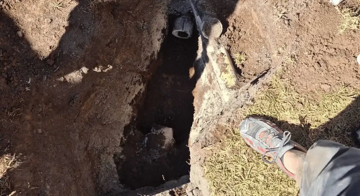 An open septic trench on a rural property, ready for pipework